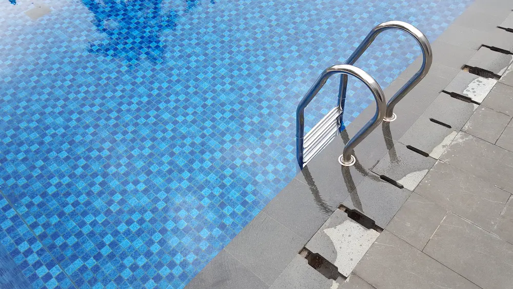 Pool ladder over blue mosaic tile