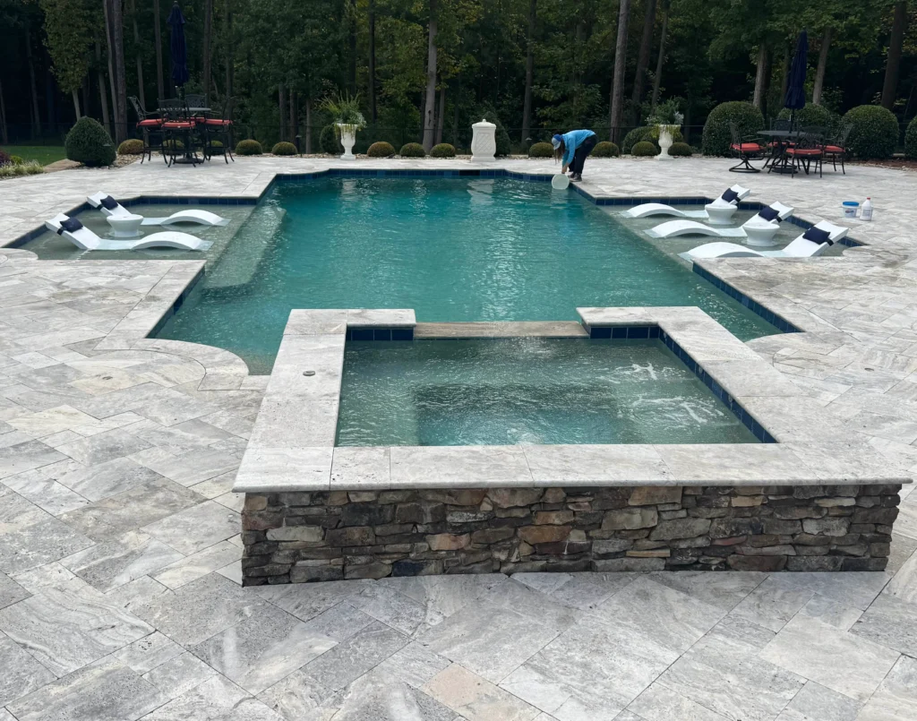 In-ground pool with a raised spa and stone coping